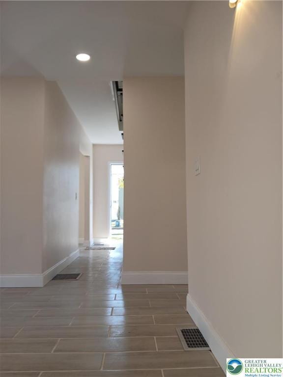 hallway with baseboards, recessed lighting, wood finish floors, and visible vents