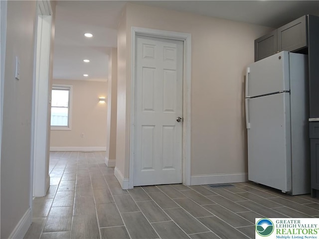 kitchen with baseboards, freestanding refrigerator, gray cabinetry, and recessed lighting
