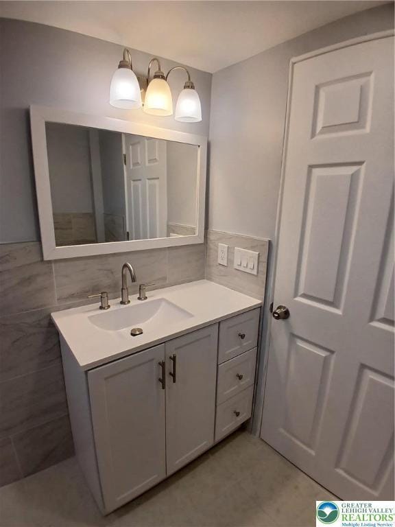 bathroom featuring vanity and tile walls