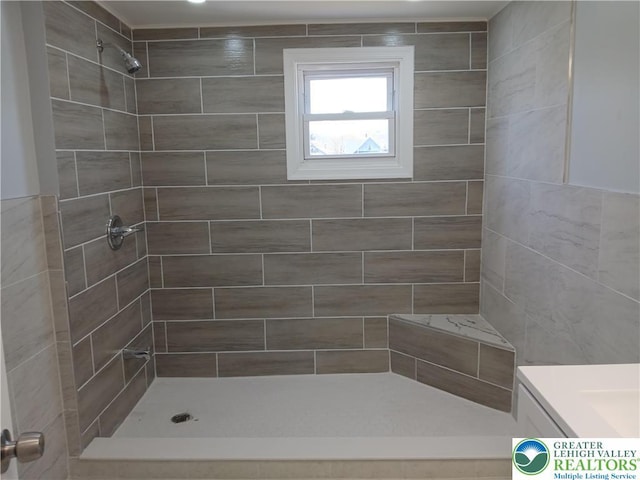 bathroom featuring vanity and tiled shower