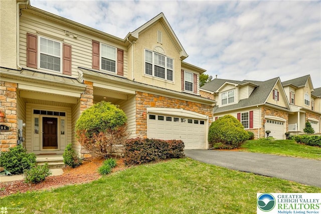 view of front of property featuring an attached garage, a front yard, stone siding, and aphalt driveway