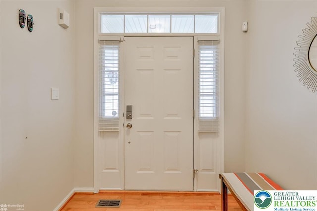 entryway with baseboards, light wood-style flooring, visible vents, and plenty of natural light