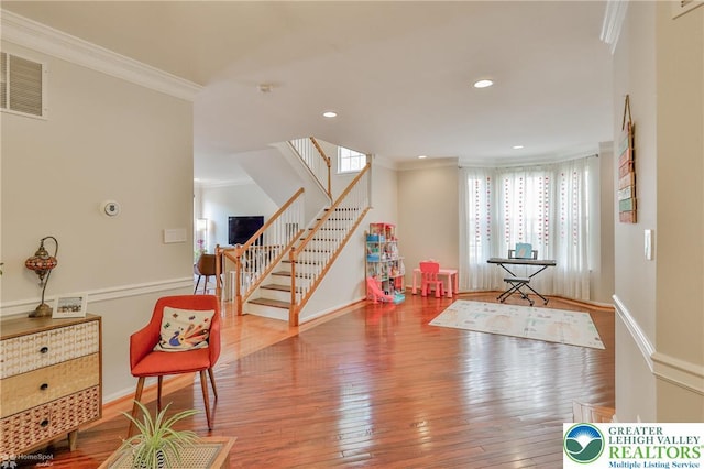 playroom featuring hardwood / wood-style floors, visible vents, baseboards, ornamental molding, and recessed lighting
