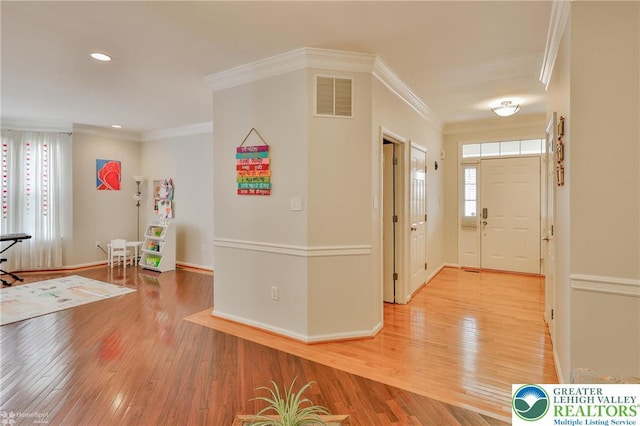 foyer entrance with light wood-type flooring, visible vents, recessed lighting, crown molding, and baseboards