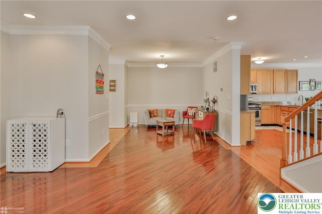 game room featuring crown molding, light wood-style flooring, and recessed lighting