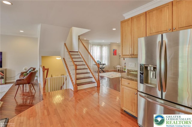 kitchen with stone countertops, recessed lighting, ornamental molding, light wood finished floors, and stainless steel fridge with ice dispenser