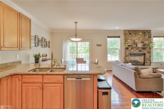 kitchen featuring dishwasher, crown molding, open floor plan, light stone countertops, and light wood-style floors