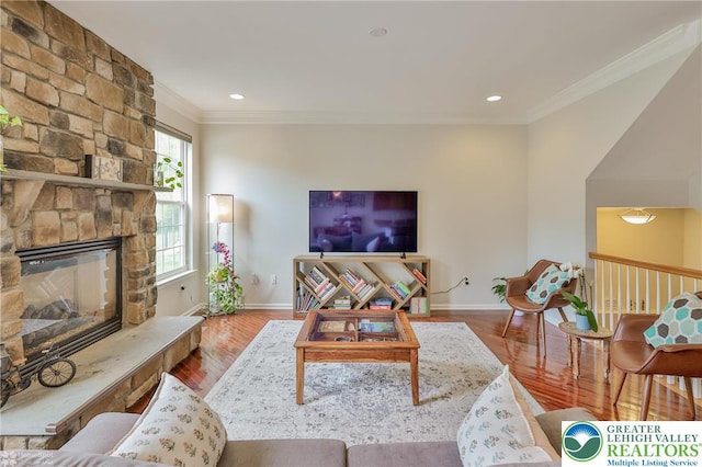 living area with recessed lighting, baseboards, crown molding, wood finished floors, and a fireplace