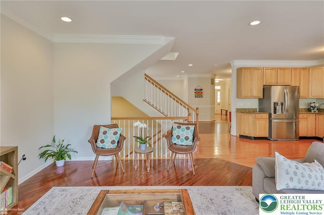 living area featuring ornamental molding, baseboards, recessed lighting, and light wood-style floors