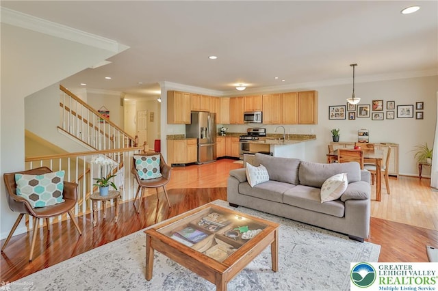 living area with stairs, crown molding, light wood-type flooring, baseboards, and recessed lighting