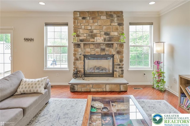 living area with ornamental molding, plenty of natural light, and wood finished floors
