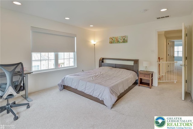 carpeted bedroom featuring multiple windows, visible vents, and recessed lighting
