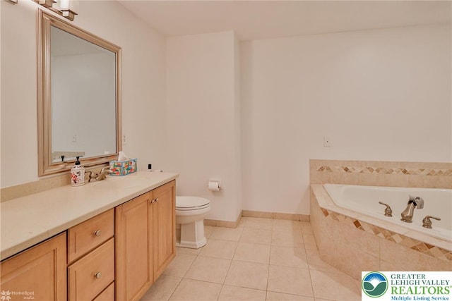 bathroom featuring toilet, a relaxing tiled tub, tile patterned floors, baseboards, and vanity