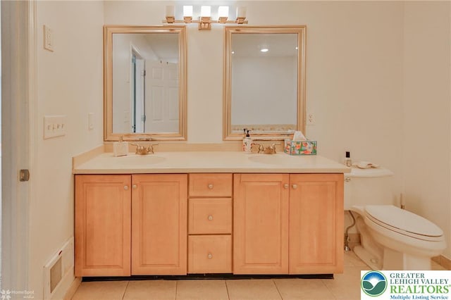 full bathroom with toilet, tile patterned flooring, double vanity, and a sink