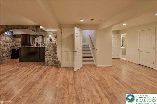 finished basement with light wood finished floors, stairway, baseboards, visible vents, and recessed lighting