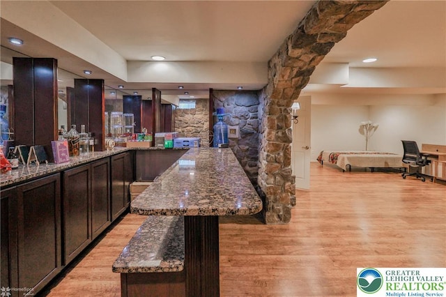 bar featuring recessed lighting, light wood-style floors, and bar area