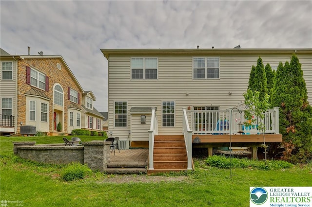 back of house with a lawn, central air condition unit, and a wooden deck