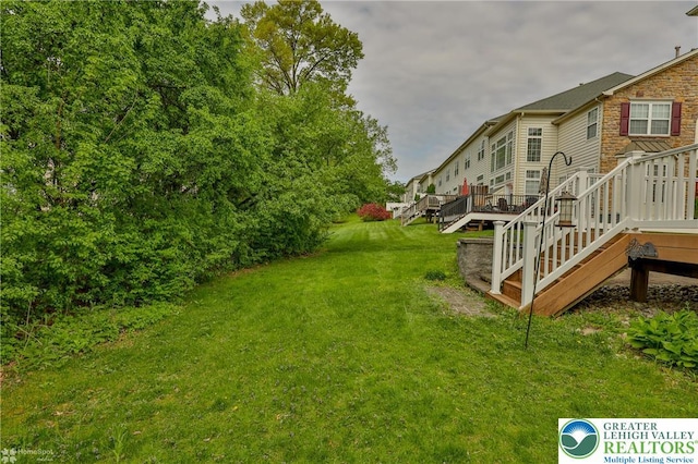 view of yard with stairs and a deck
