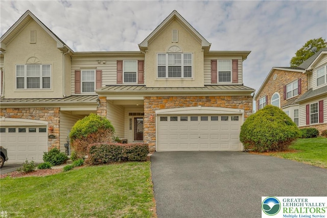 multi unit property with an attached garage, driveway, stone siding, and a standing seam roof