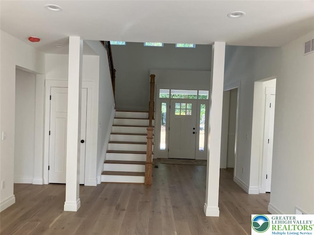 foyer with recessed lighting, baseboards, wood finished floors, visible vents, and stairway