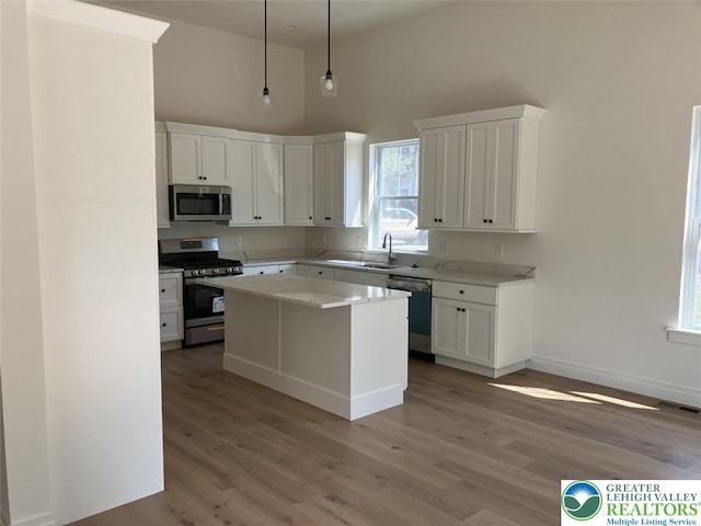 kitchen featuring visible vents, light countertops, white cabinets, light wood-style flooring, and appliances with stainless steel finishes