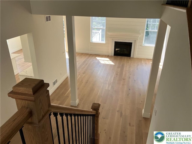 living room with baseboards, visible vents, and wood finished floors