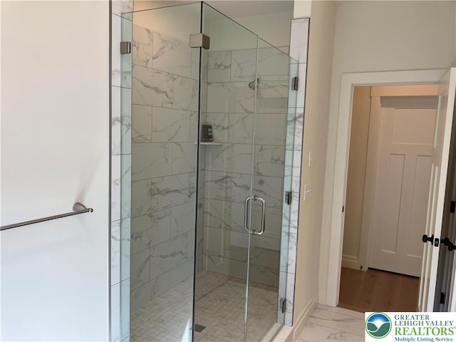full bathroom with baseboards, a shower stall, and marble finish floor