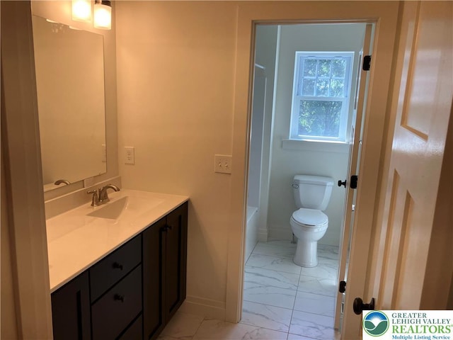 full bath featuring vanity, marble finish floor, toilet, a washtub, and baseboards