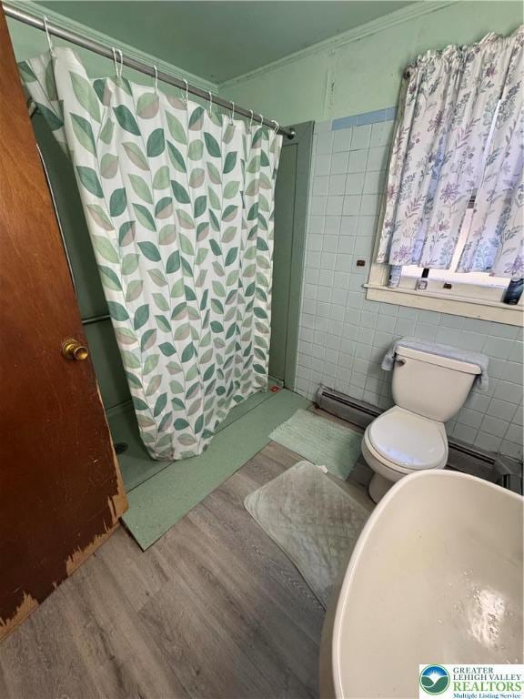 bathroom with crown molding, wood finished floors, tile walls, and curtained shower