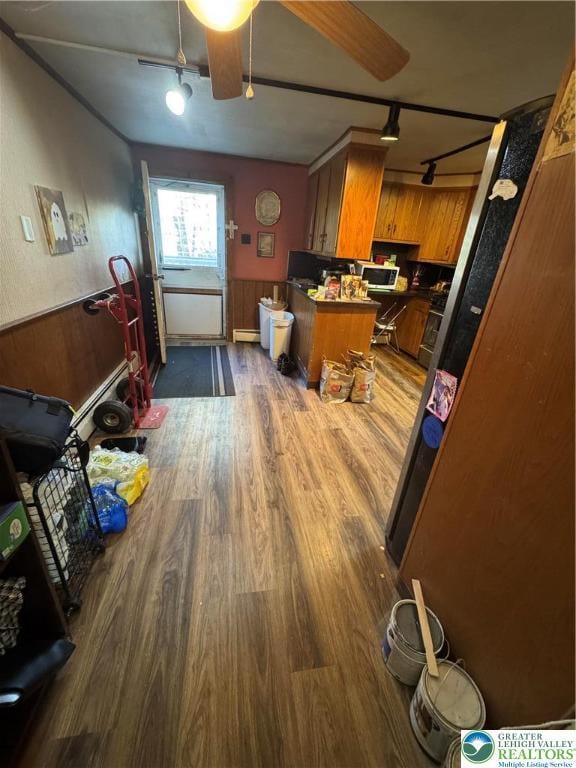 kitchen featuring brown cabinets, rail lighting, dark wood-style floors, and ceiling fan