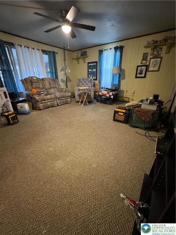 carpeted living room featuring a ceiling fan