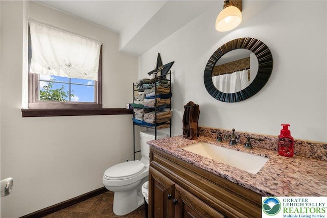bathroom featuring vanity, baseboards, and toilet