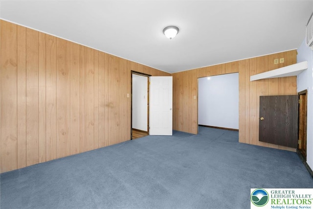 unfurnished bedroom with wood walls and carpet flooring