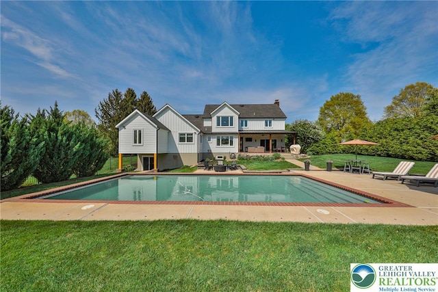 outdoor pool with a lawn and a patio