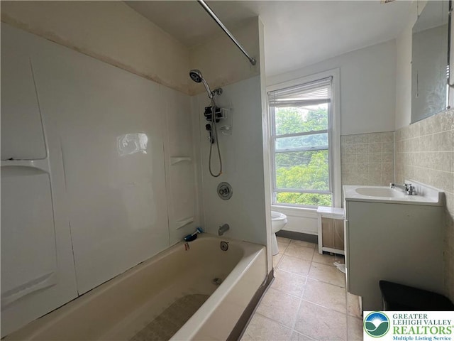 full bath featuring vanity, toilet, tile walls, shower / tub combination, and tile patterned floors