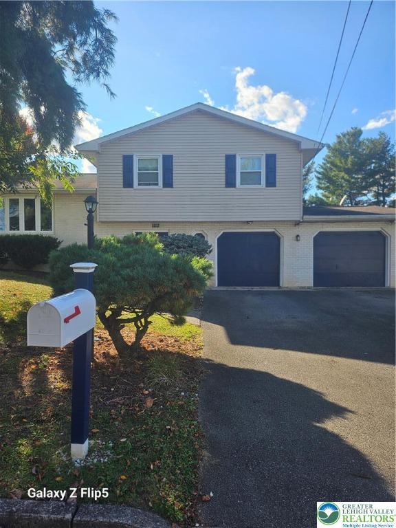 view of front of house featuring driveway and brick siding