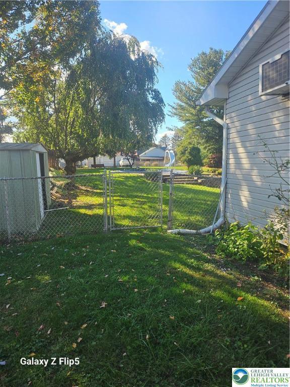 view of yard with an outdoor structure, fence, and a shed