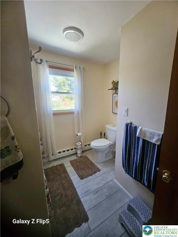 bathroom featuring wood finished floors and toilet