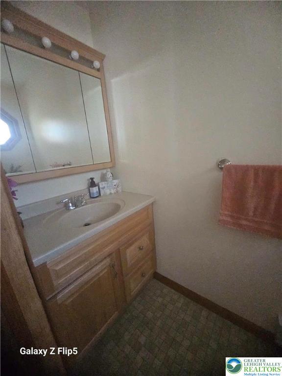 bathroom featuring vanity, baseboards, and tile patterned floors