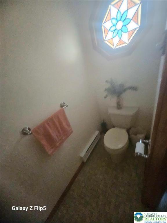 bathroom with baseboard heating and toilet