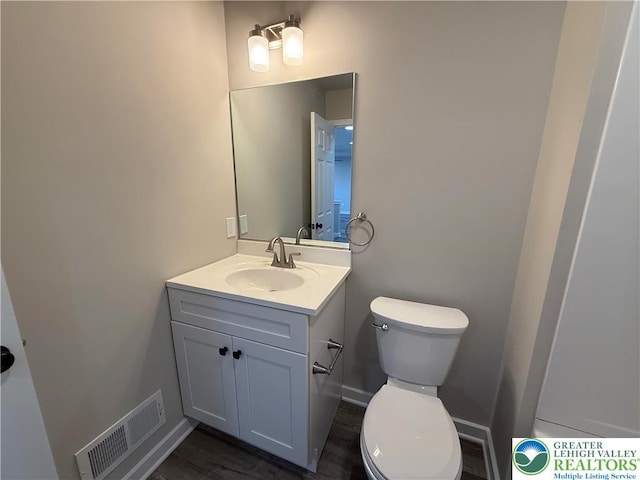 bathroom featuring vanity, toilet, and visible vents
