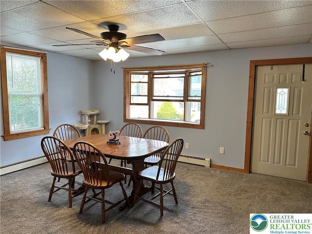 carpeted dining room with plenty of natural light, baseboard heating, and a paneled ceiling