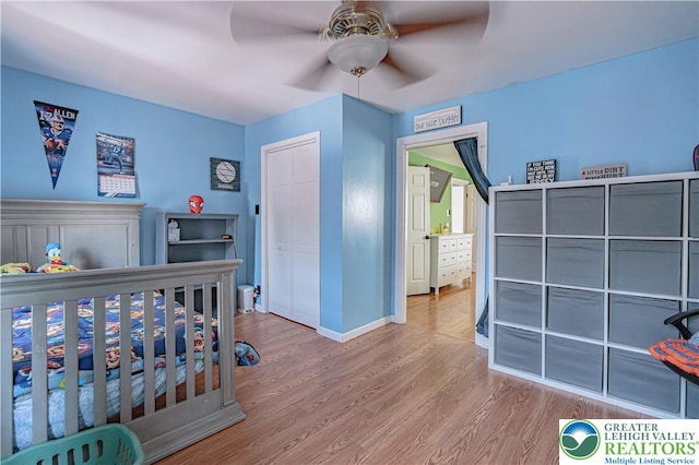 bedroom featuring a ceiling fan, baseboards, wood finished floors, and a closet