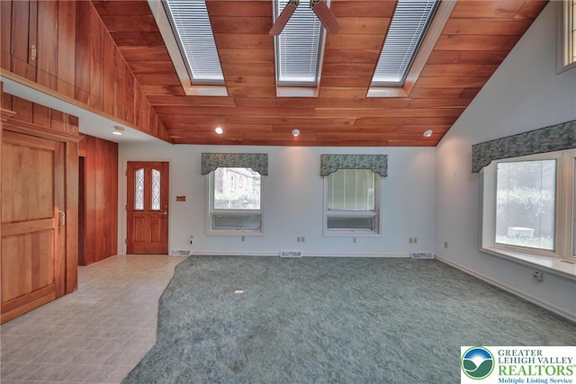 spare room featuring wood ceiling, baseboards, light carpet, and lofted ceiling with skylight