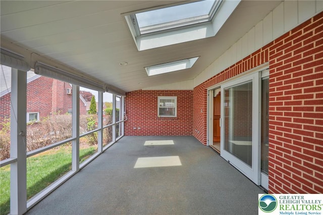 unfurnished sunroom featuring a skylight