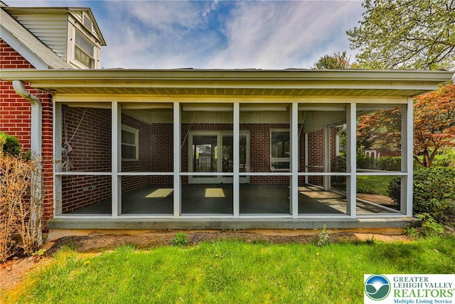 exterior space featuring brick siding and a sunroom