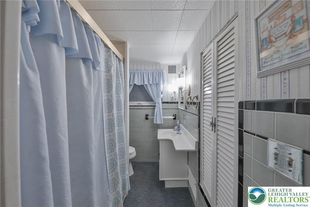 full bathroom with vanity, visible vents, toilet, tile walls, and tile patterned floors