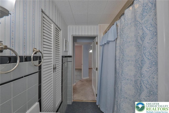 hall featuring carpet floors and wallpapered walls