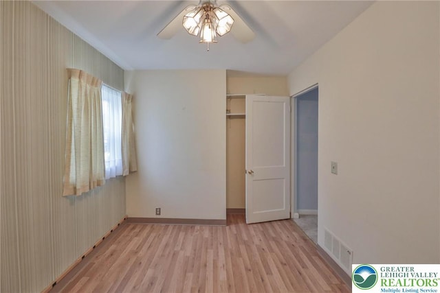 unfurnished bedroom featuring baseboards, ceiling fan, light wood finished floors, and visible vents