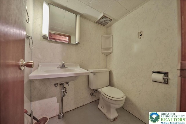 half bath featuring toilet, visible vents, and finished concrete flooring